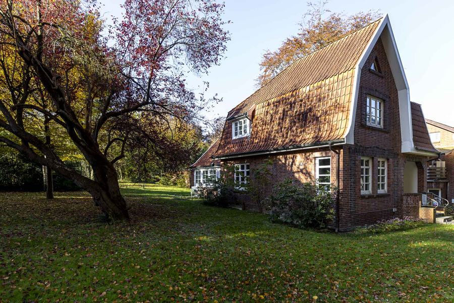 Garten mit altem Obstbaum und Seitenansicht des Hauses