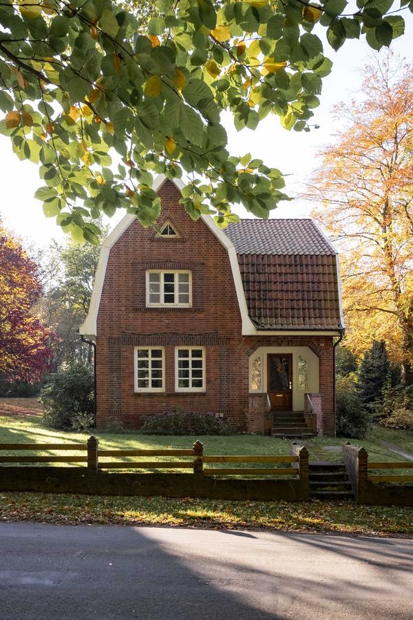 Hausfront mit Eingang und Herbstlaub
